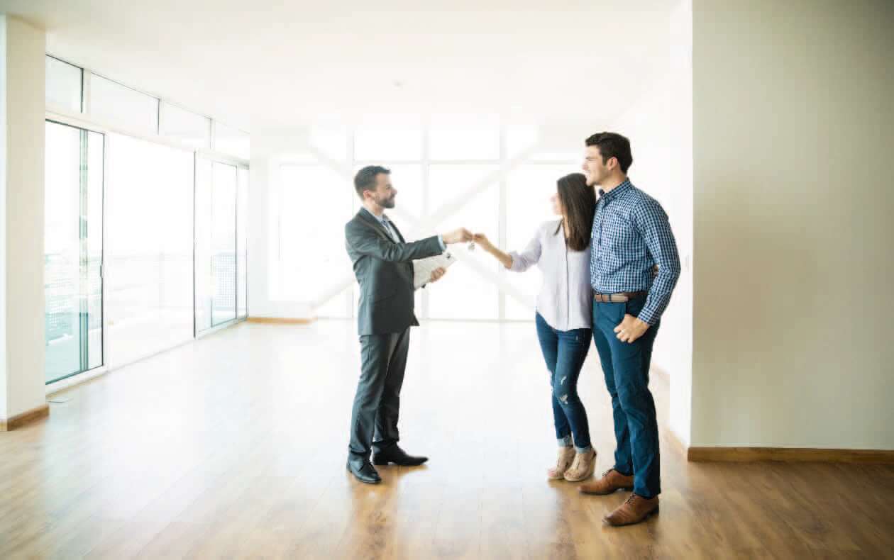 Pareja recibiendo las llaves de una casa