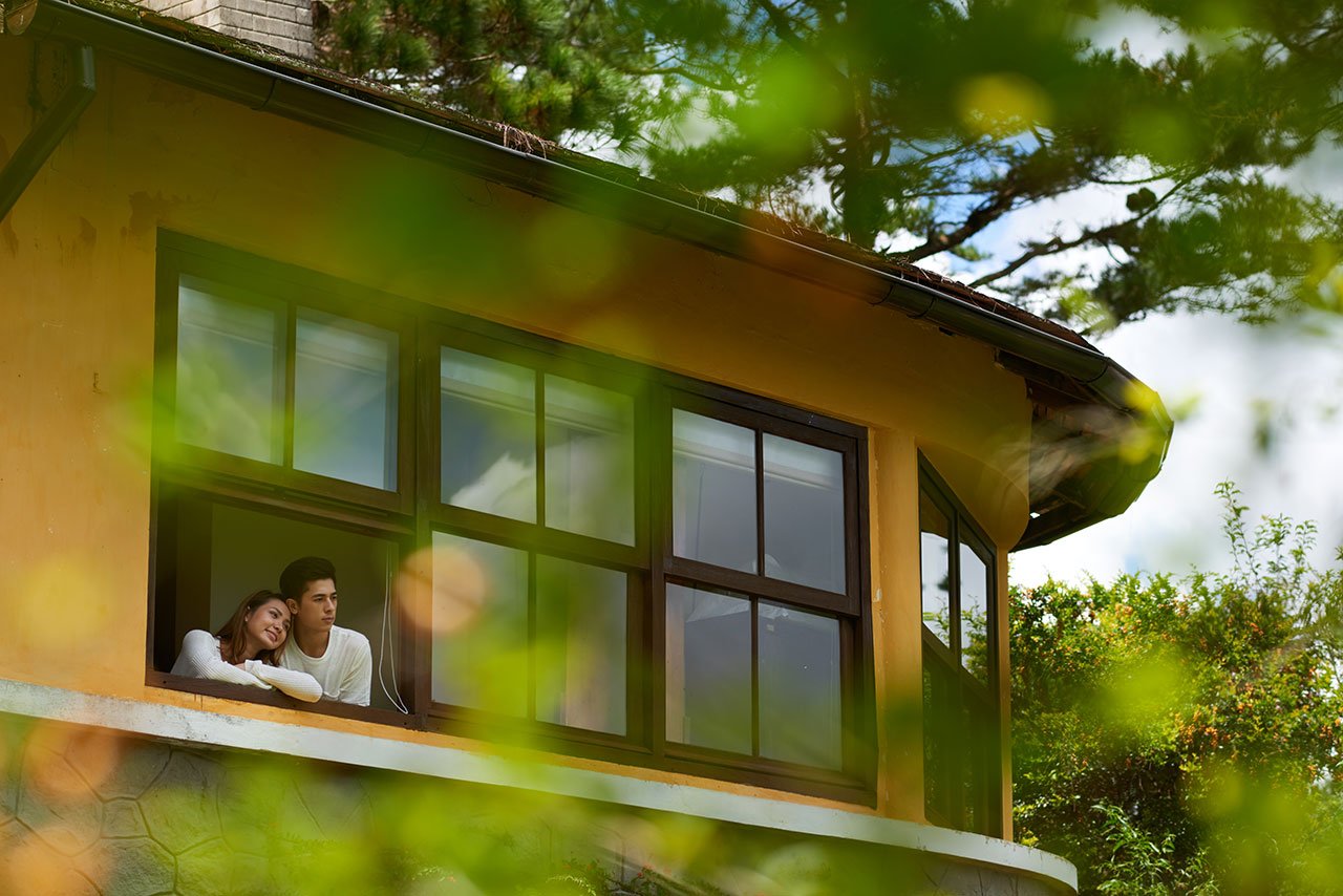 pareja mirando hacia el exterior de su casa