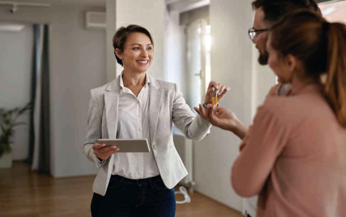 Mujer entregando llaves de una vivienda