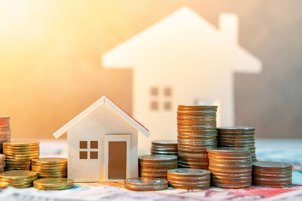 Monedas junto a una casa