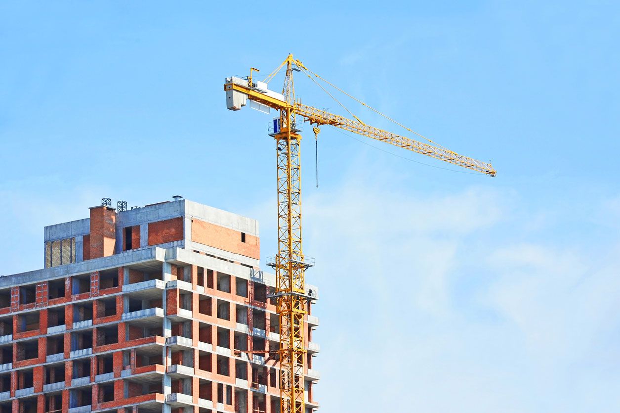 Grúa y el sitio de la construcción de rascacielos