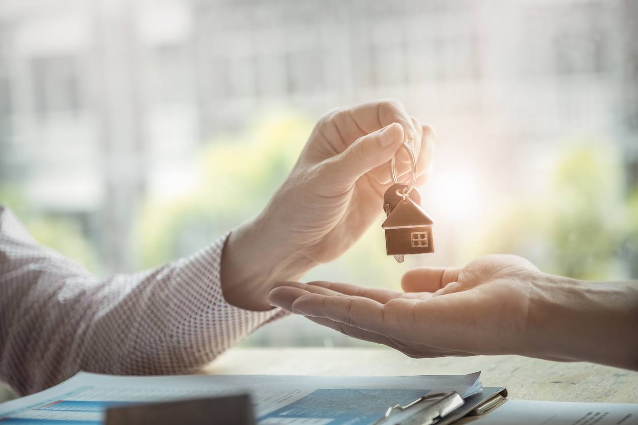 Persona enregando llaves de una casa nueva