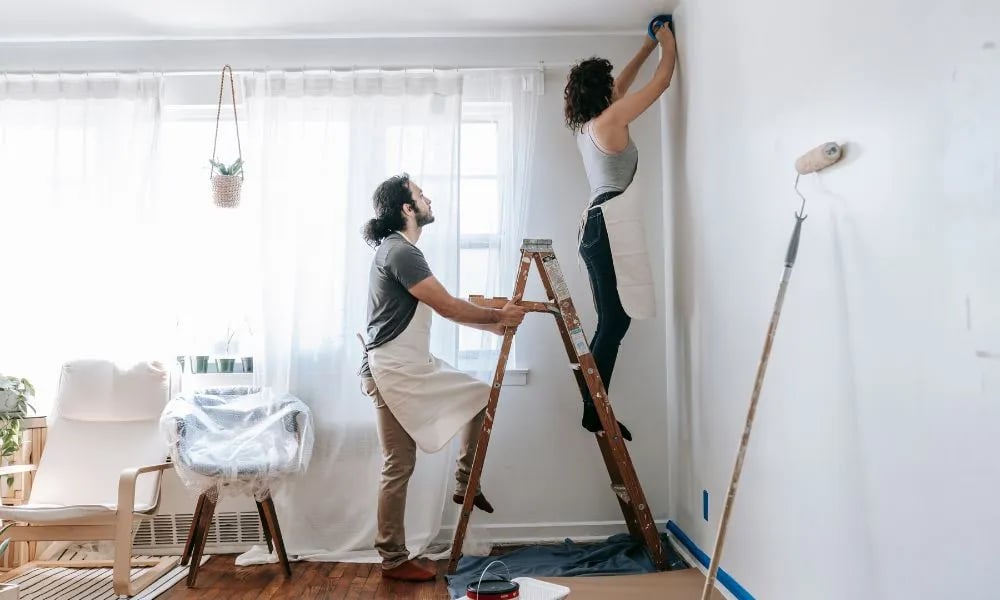 Pareja pintando una casa